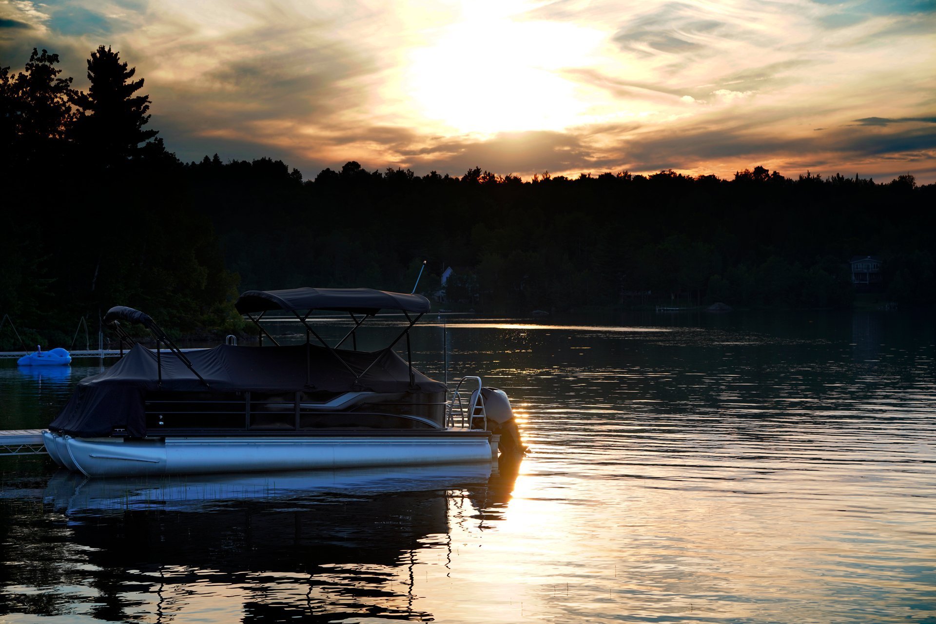 Pontoon boat on lake with evening sunset