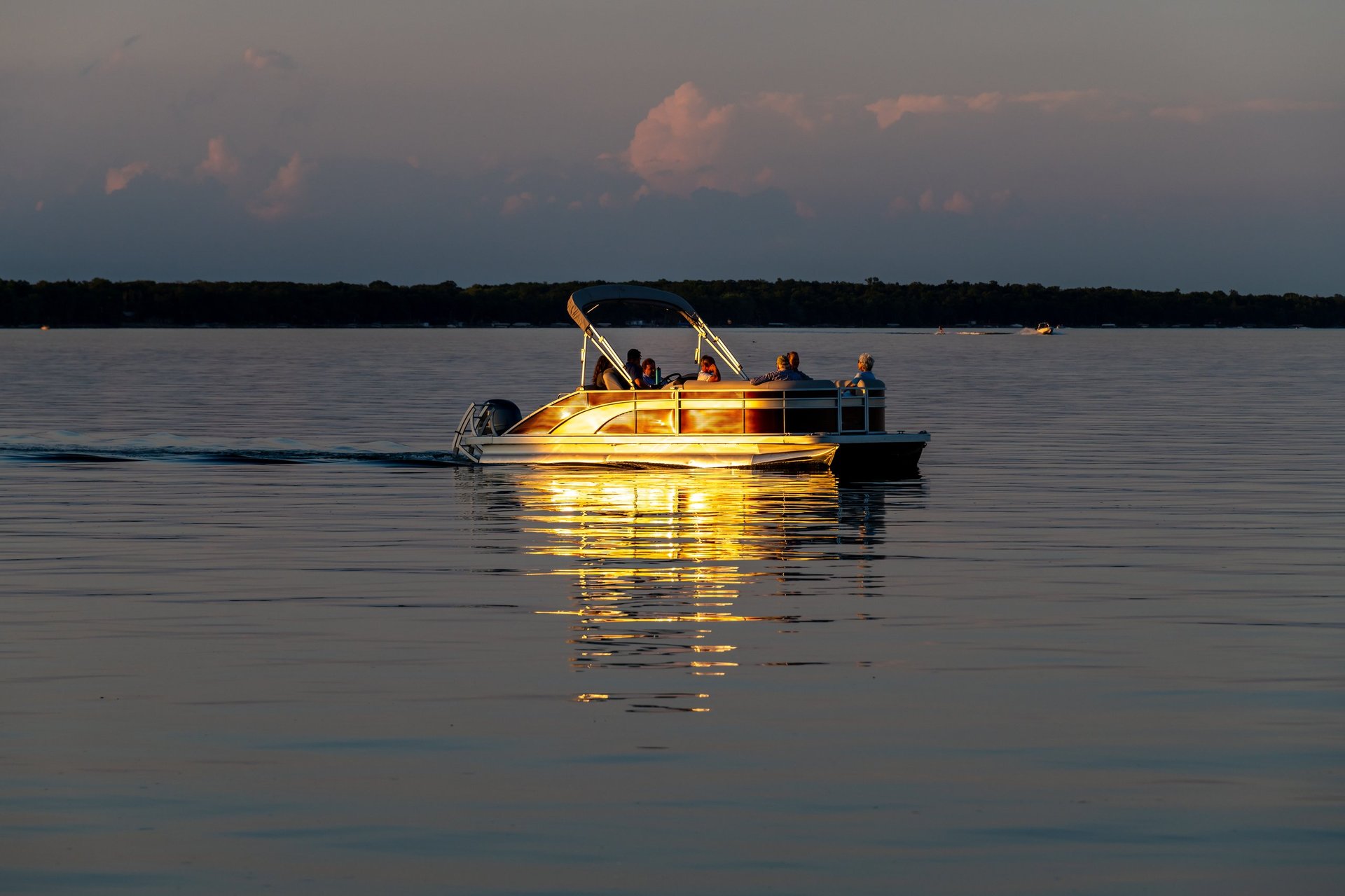 Pontoon boat on Otter Tail Lake at sunset